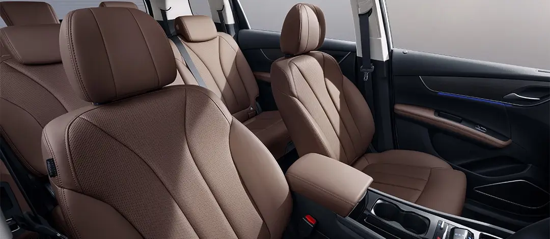 BYD M6 front seats with tan leather upholstery featuring perforated surfaces and ergonomic design details.