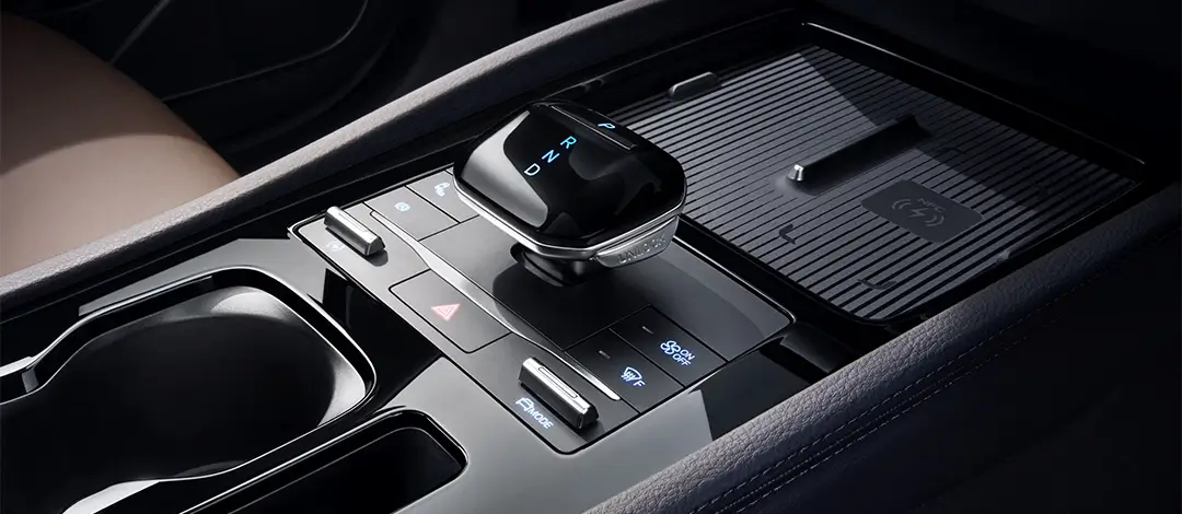 BYD M6 center console with modern gear selector, wireless charging pad and premium interior trim details