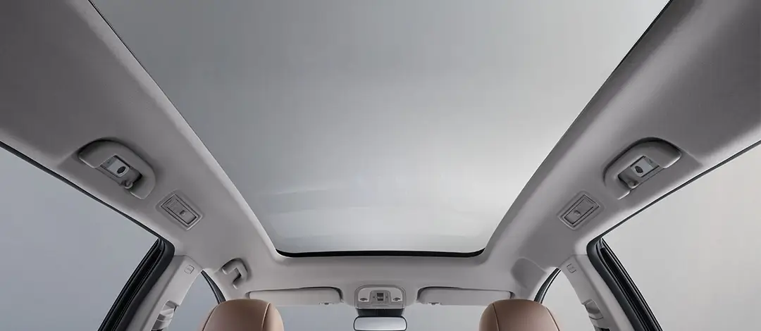 BYD M6 panoramic sunroof interior view showing large glass panel and spacious cabin with brown leather seats.
